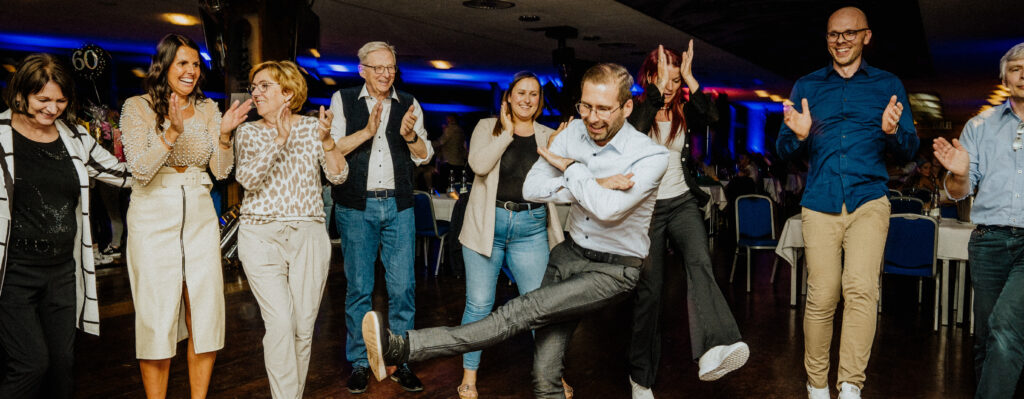 Gruppe von Menschen tanzt und feiert bei einer Veranstaltung – professionelle Eventfotografie von Yourfilms.