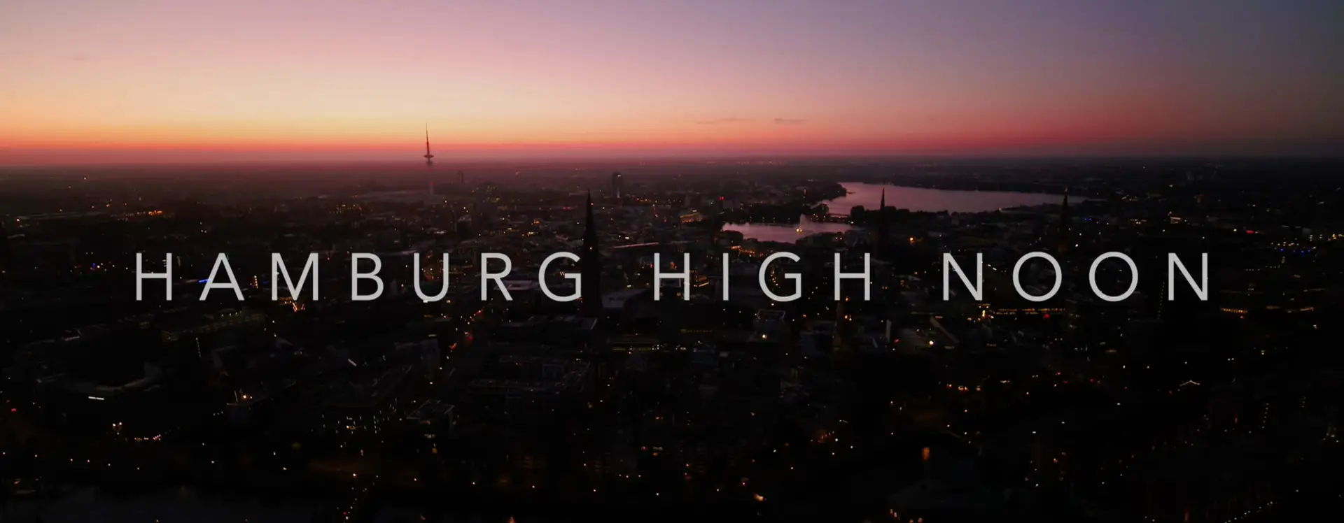 Luftaufnahme von Hamburg bei Sonnenuntergang mit dem Filmtitel Hamburg Highnoon in moderner Schrift. Ein atmosphärischer Shot, der die nächtliche Spannung des Films einfängt.